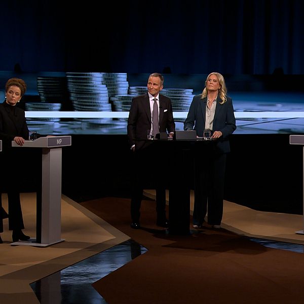 Fyra partiledare står vid talarpodium i tv-sänd politisk debatt.