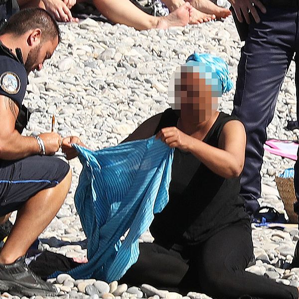 En kvinna tvingades i går av fransk polis att ta av sig sin heltäckande tunika på en strand i Nice. 15 städer i Frankrike har infört ett förbud mot burkinin – däribland Nice.