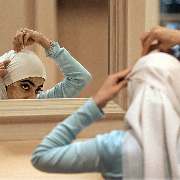 TT-bild: ”** ADVANCE FOR FRIDAY NOV. 10 ** FILE ** Sadaf Butt, of Alabama, adjusts her hijab in a mirror at the 43rd annual Islamic Society of North America convention, Sept, 1, 2006, in Rosemont, Ill. Earlier this year on an Arabic Web site, a Muslim woman scholar posted an open letter to the Islamic world for women to take off the veil _ that head scarves and other coverings for women are not mandated by the Quran or Islamic tradition. (AP Photo/M. Spencer Green)”