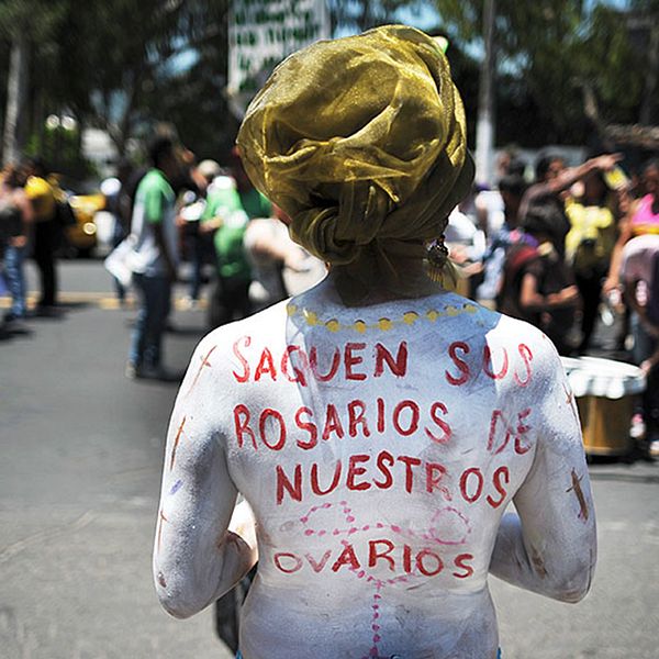 ”Ta era radband ur våra äggstockar” har en kvinna skrivit på sin rygg vid en abortdemonstration i San Salvador.