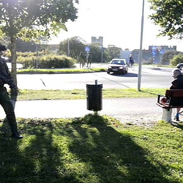 Soldat står och tittar på en parkbänk