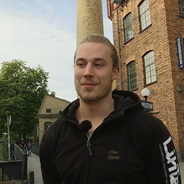 Jesper Rosenberg står framför en tegelbyggnad.