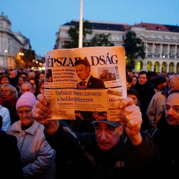 En demonstrant håller upp det sista tryckta exemplaret av den nu nedlagda oppositionella tidningen Népszabadság.