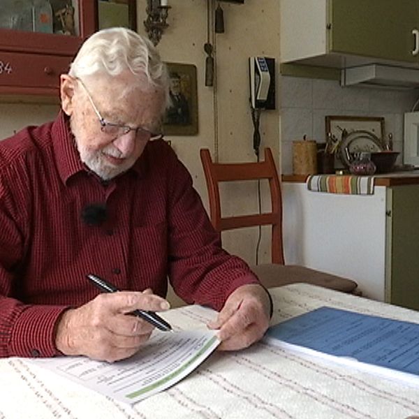 Stig Sköld sitter vid sitt bord och fyller i ett formulär.