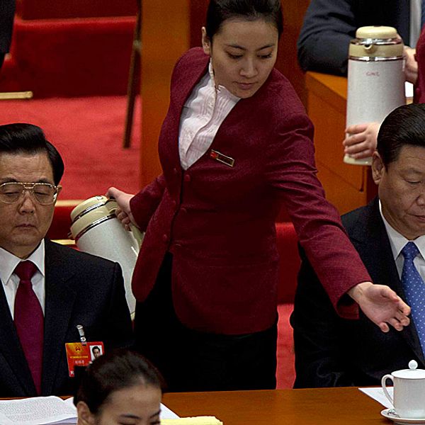 Kinas avgående president Hu Jintao och hans förväntade efterträdare Xi Jinping får påfyllning av te av två värdinnor vid folkkongressens öppnande.