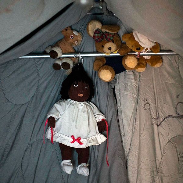 Dockor och teddybjörnar hänger i ett tält