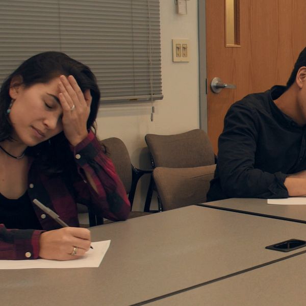 En bild på ett par studenter som skriver ner vad de minns.