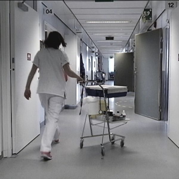 sjuksköterska går med vagn i korridor