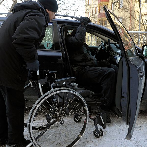 Färdtjänsttaxi i Stockholm. En man med rullstol ska kliva in i en bil.