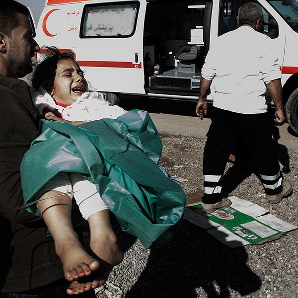 En pappa springer med sin dotter till ambulansen som ska ta henne vidare till Erbil och bättre sjukvård