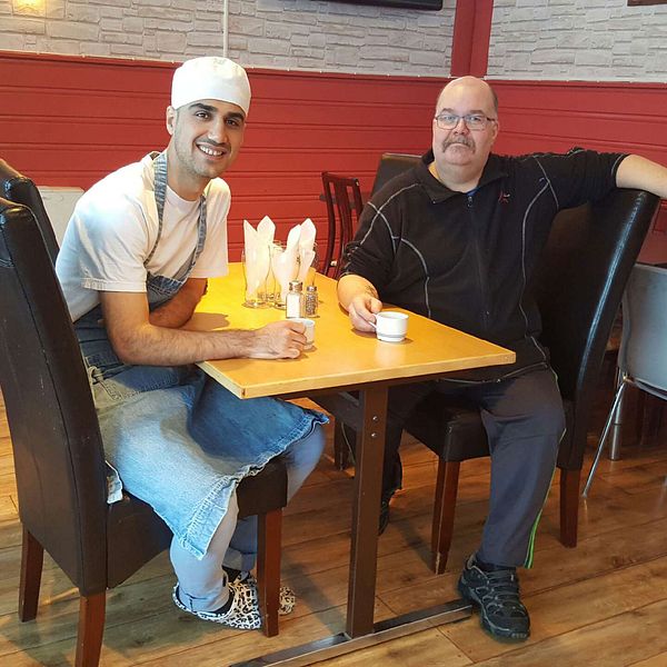 Danyar Mohammed och Nicklas Lundmark i Jokkmokk sitter vid ett bord inne på pizzerian.