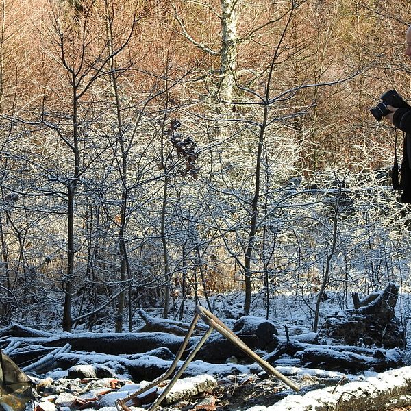 Man med kamera vid snöig brandplats