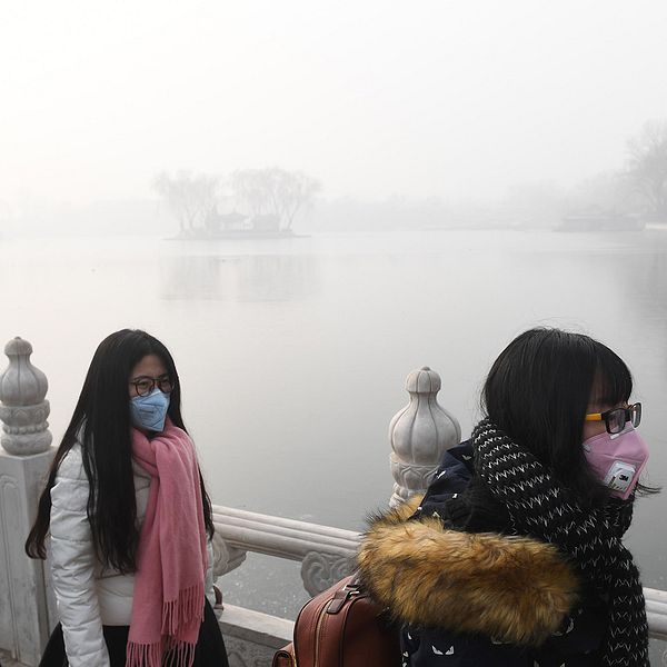 Kvinnor med munskydd i Peking 1 januari 2017 när staden åter drabbades av kraftiga luftföroreningar.