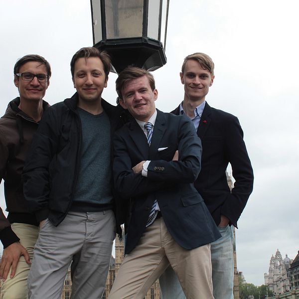 Fyra unga män poserar vid lyktstolpe i London