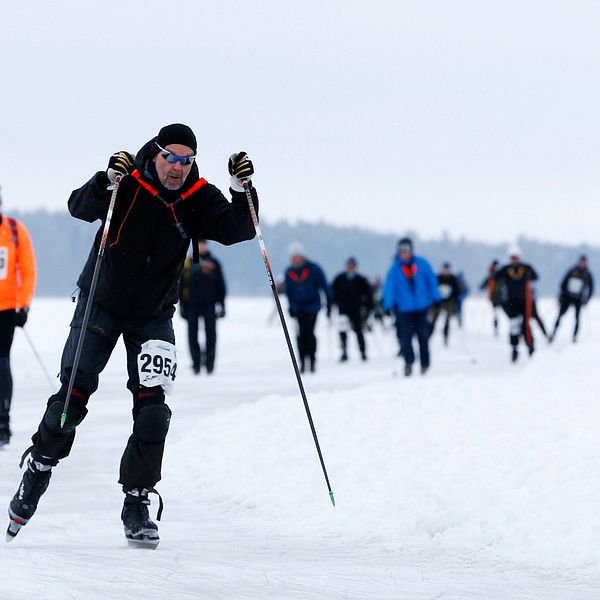 Flera personer med skridskor stakar sig fram på isen