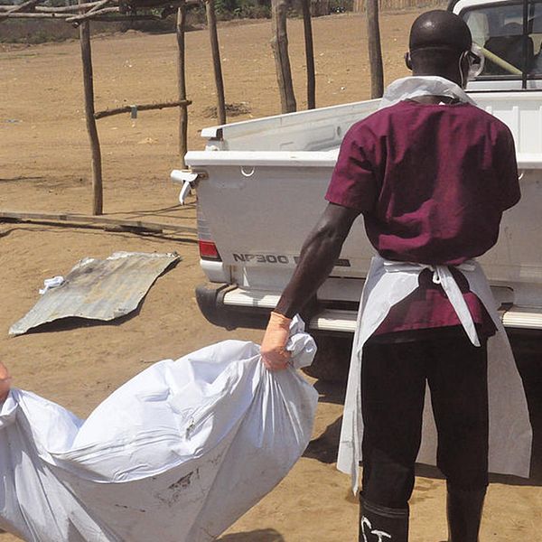 Sjukvårdspersonal tar hand om kroppen efter en person som dött av ebola