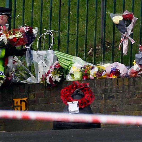 Londonpolisen arrangerar blommor som lagts vid platsen på mordet den 23 maj i Woolwich.