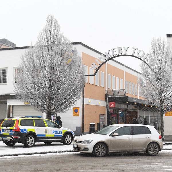 Polisbil parkerad vid Rinkeby torg.
