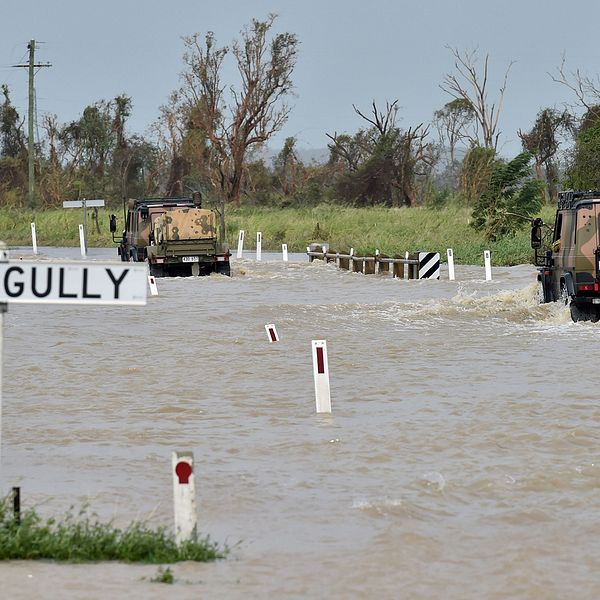 Militärfordon kör genom vattenmassor i närheten av staden Bowen.