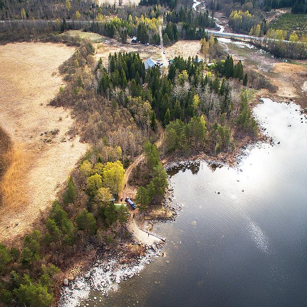 SVT Nyheter har flugit med drönare över sökområdet – en gård i ett skogsparti vid vattnet några mil från Hudiksvall.