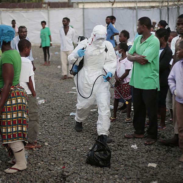 Personer som skrivits ut från en klinik i Liberia sprejas på väg ut därifrån.