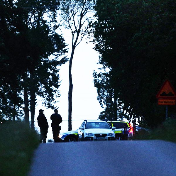 Poliser utanför den gård där två personer hittades döda måndagen den 12 juni.