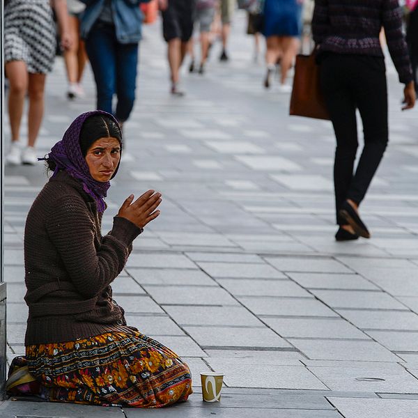 En kvinna tigger vid Sergels torg i Stockholm.