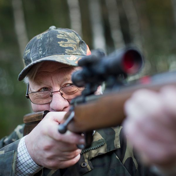 en man i kamouflagekläder siktar med gevär