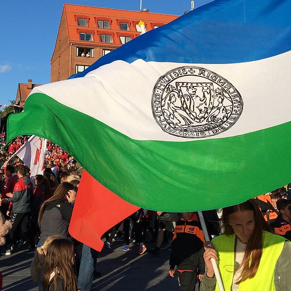 massor av folk på torg, Jämtlands-flagga