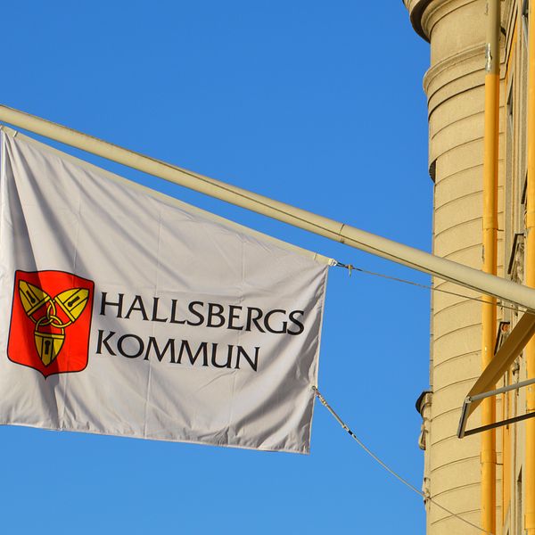 Flagga med Hallsbergs kommunvapen och texten Hallsberg kommun.