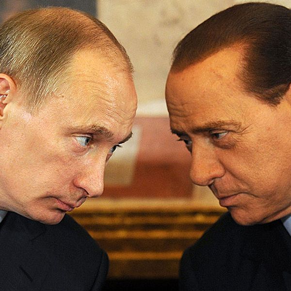 Rysslands president Vladimir Putin lutar sig mot Italiens förre premiärminister Silvio Berlusconi