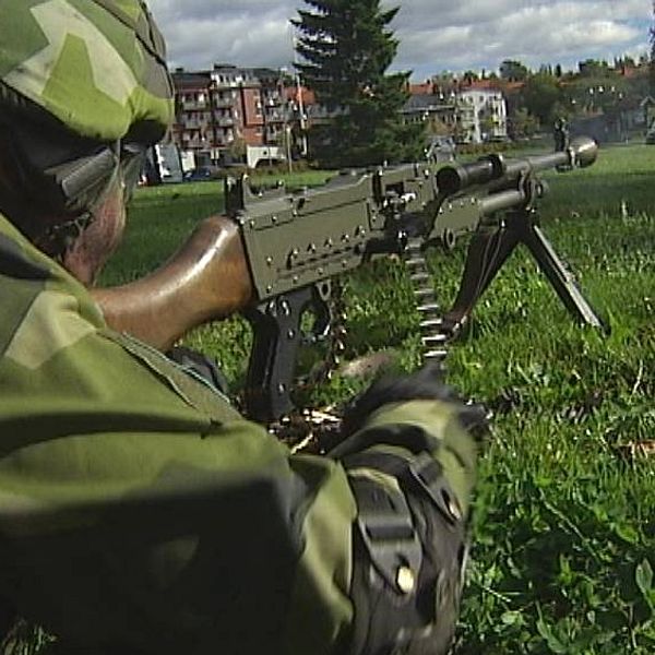 Soldat med vapen i stadsmiljö