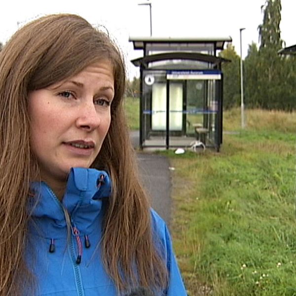 Kvinna intervjuas vid busshållplats.