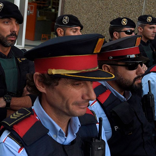 Katalanska poliser från regionala styrkan Mossos d'esquadra står framför medlemmar av spanska Guardia Civil.