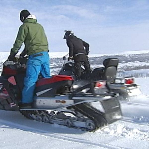 två personer på skotrar på kalfjället