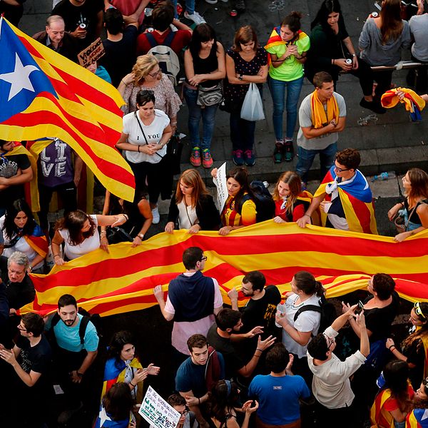Demonstranter håller upp den katalanska flaggan.