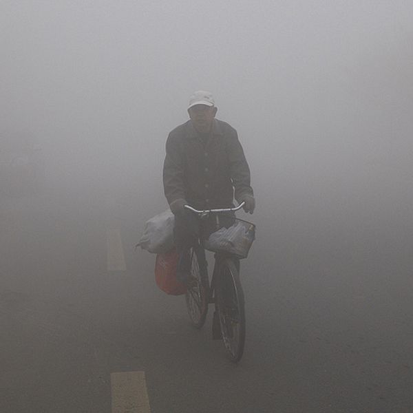 En cyklist navigerar genom smogen i Harbin
