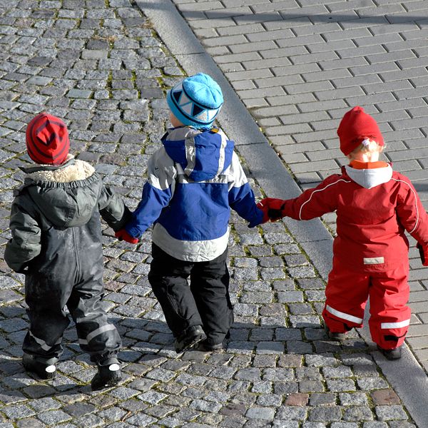 Småbarn som promenerar hand i hand.