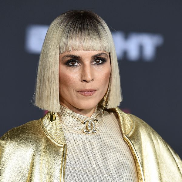 Skådespelaren Noomi Rapace i guldjacka, guldtröja och guldhalsband.