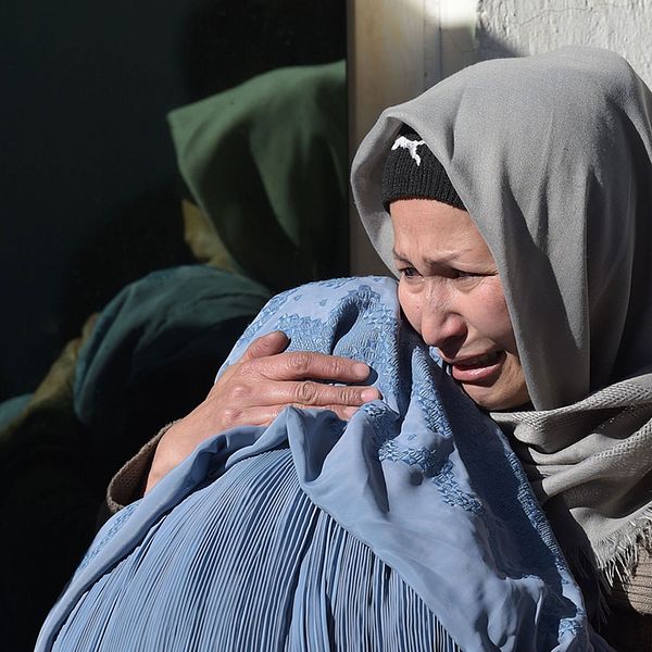 Två kvinnor sörjer sina anhöriga på ett sjukhus efter attacken i Kabul.