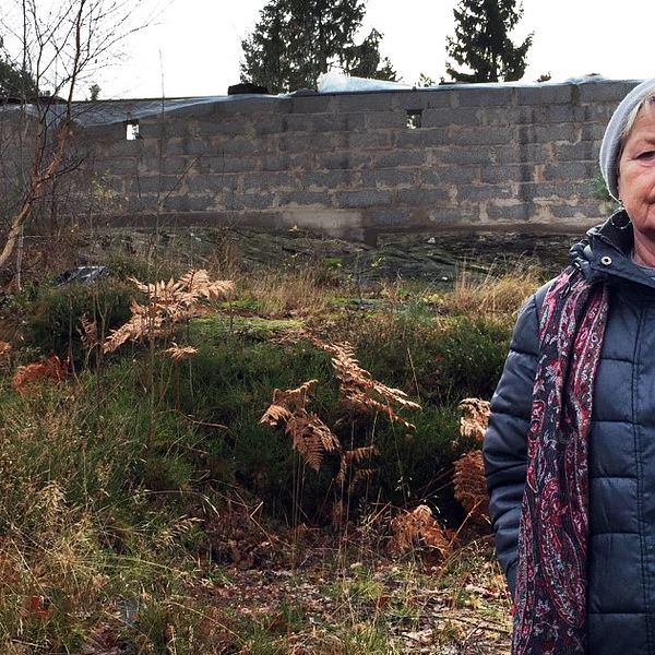 Kvinna står framför en murad husgrund