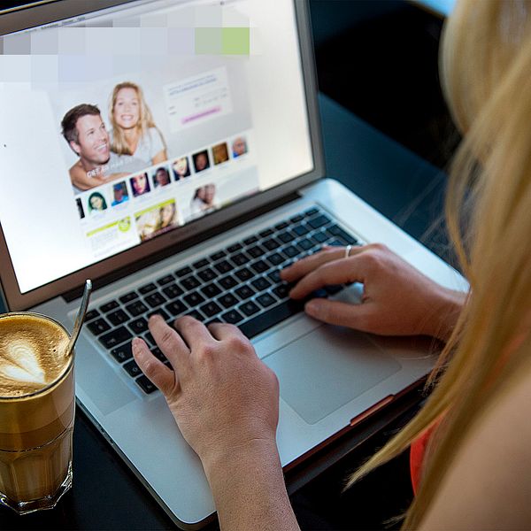 En kvinna sitter vid en dator och surfar på en sajt för nätdejting.