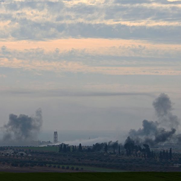 Rökmoln från flygbomber stiger från flera platser i en stad i syriska provinsen Idlib.