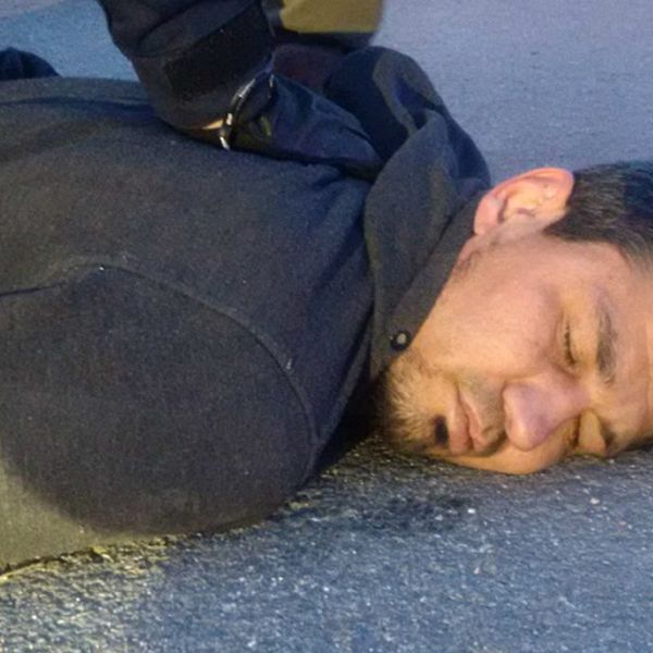 En bild föreställande misstänkte terroristen Rakhmat Akilov liggandes på asfalt med polisers armar över sig.