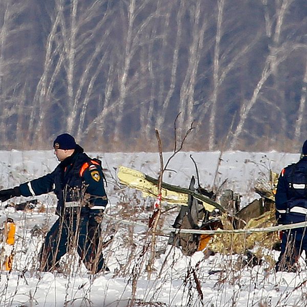 Räddningsarbetare arbetar vid platsen där det ryska flygplanet kraschade på söndagen.