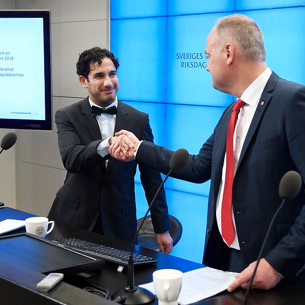 Civilminister Ardalan Shekarabi och Vänsterpartiets ledare Jonas Sjöstedt skakar hand vid en presskonferens.