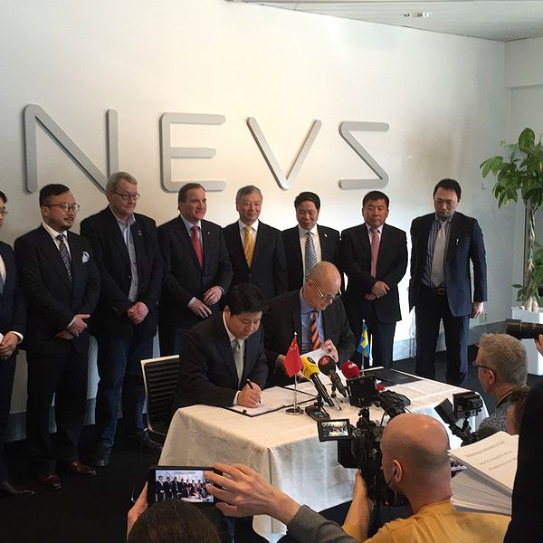 Stefan Tilk, vd på Nevs och Mr Jianghua Su, en av GSR Capitals ordförande skriver under ett samarbetsavtal med medarbetare, samt Stefan Löfven i bakgrunden.