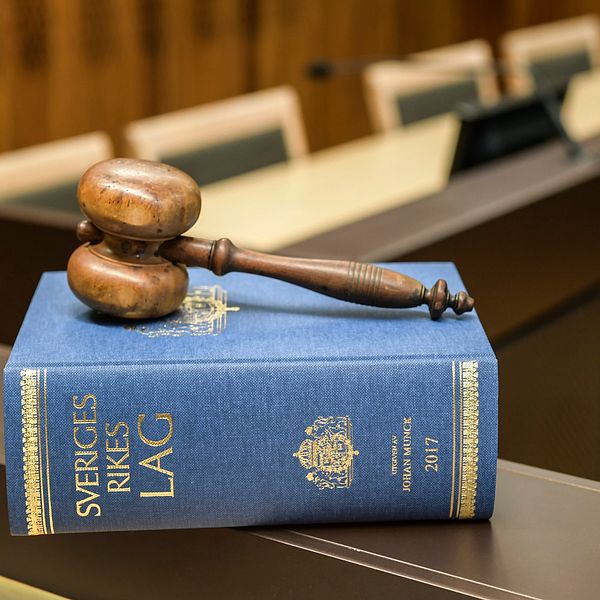 lagbok och klubba på bänk i rättssal