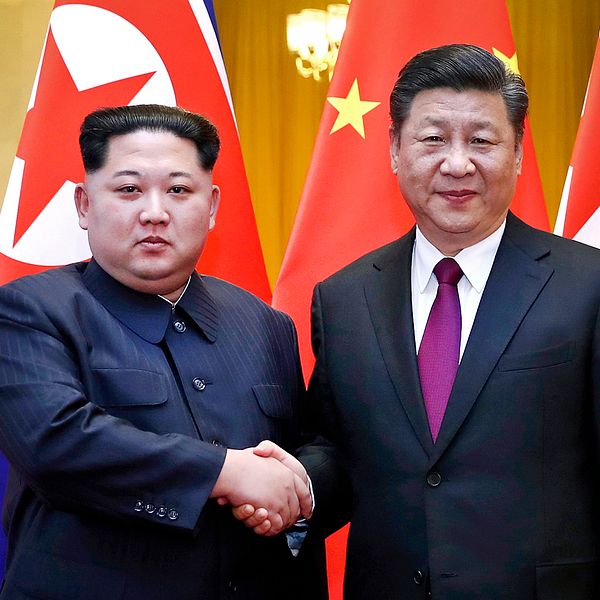 Nordkoreas diktator Kim Jong-un skakar hand med Kinas president Xi Jinping under ett möte i Peking, i slutet av mars 2018