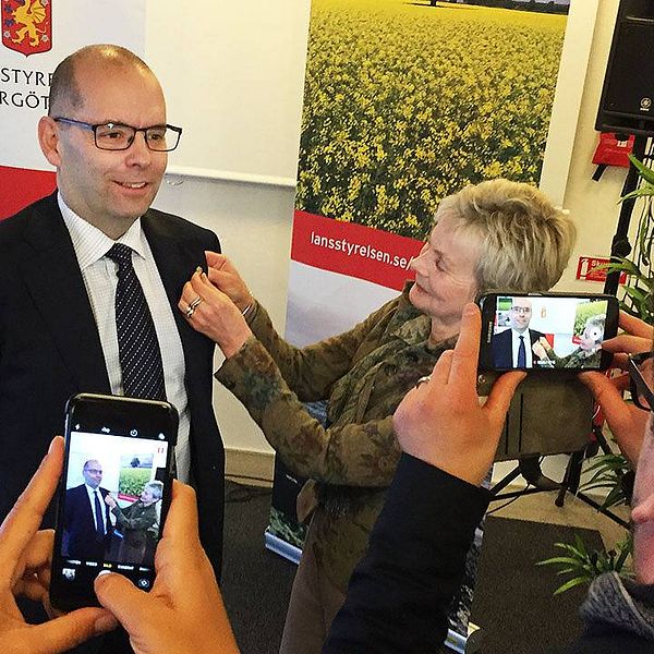 tillträdande landshövding Östergötland Carl Fredrik Graf får en pin med det östgötska vapnet från nuvarande landshövding Elisabeth Nilsson
